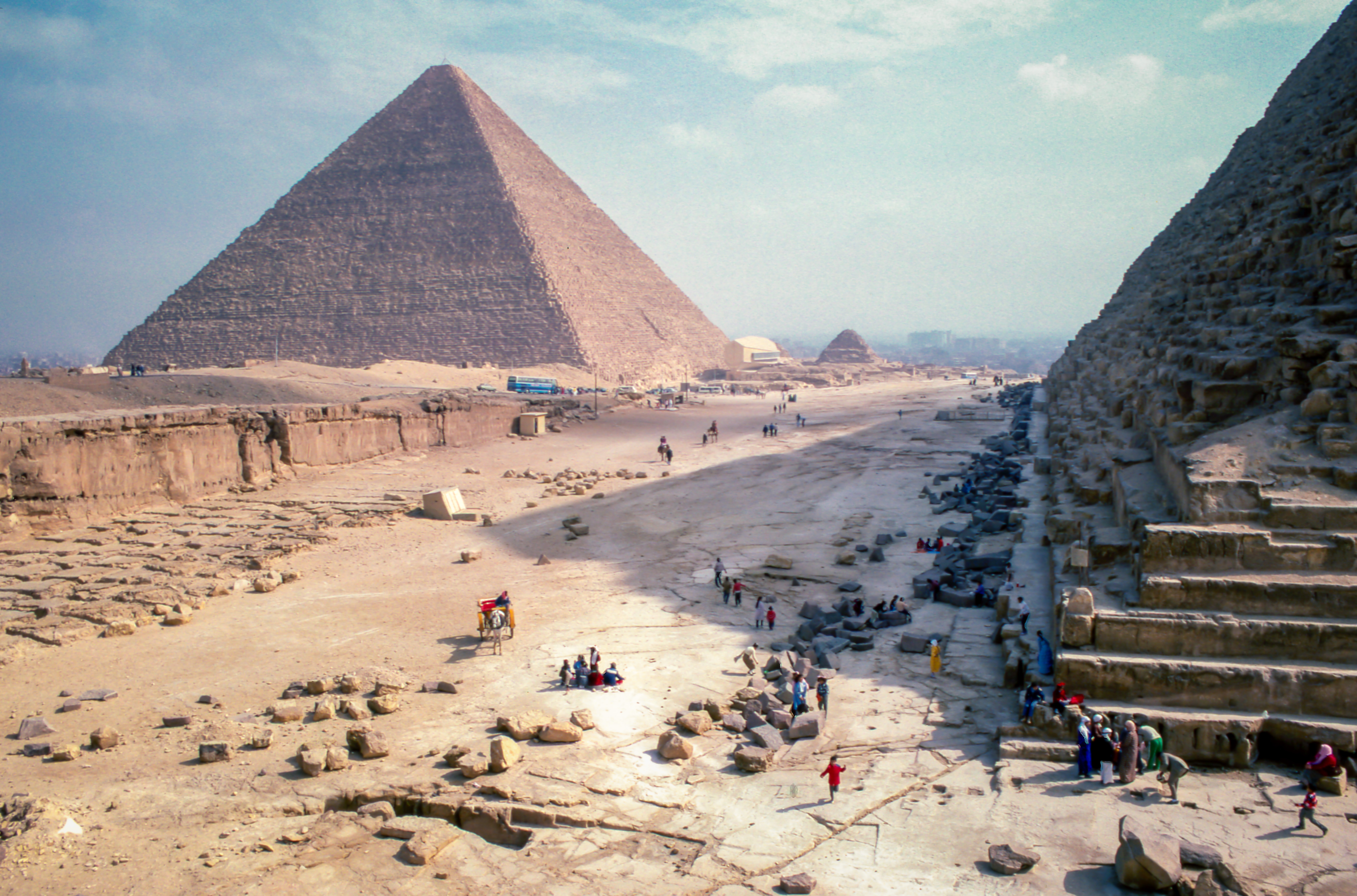 The picture shows one of the pyramids in Giza with workers in the background.