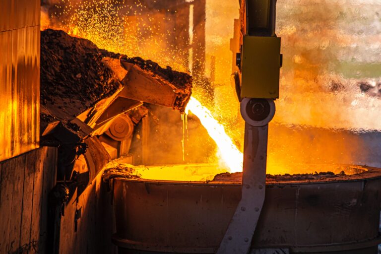 Molten metal pouring into a huge crucible at a steelworks